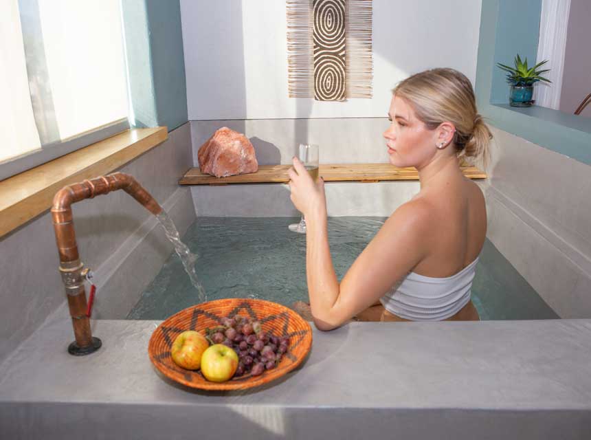 Woman in the In room private soaking tub in a Spa Suite
