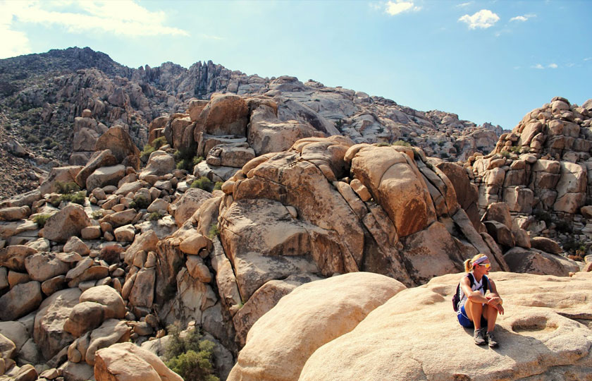 Joshua Tree - Woman hiker sitting on big rock formations